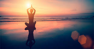 mindfulnes image of person sitting on beach at sunrise